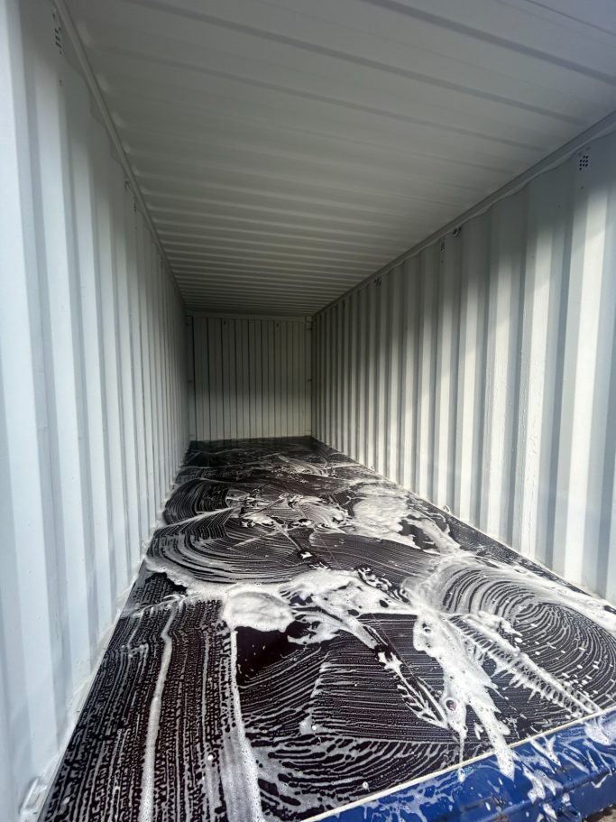 the interior of a hi cube 20 foot shipping container being cleaned