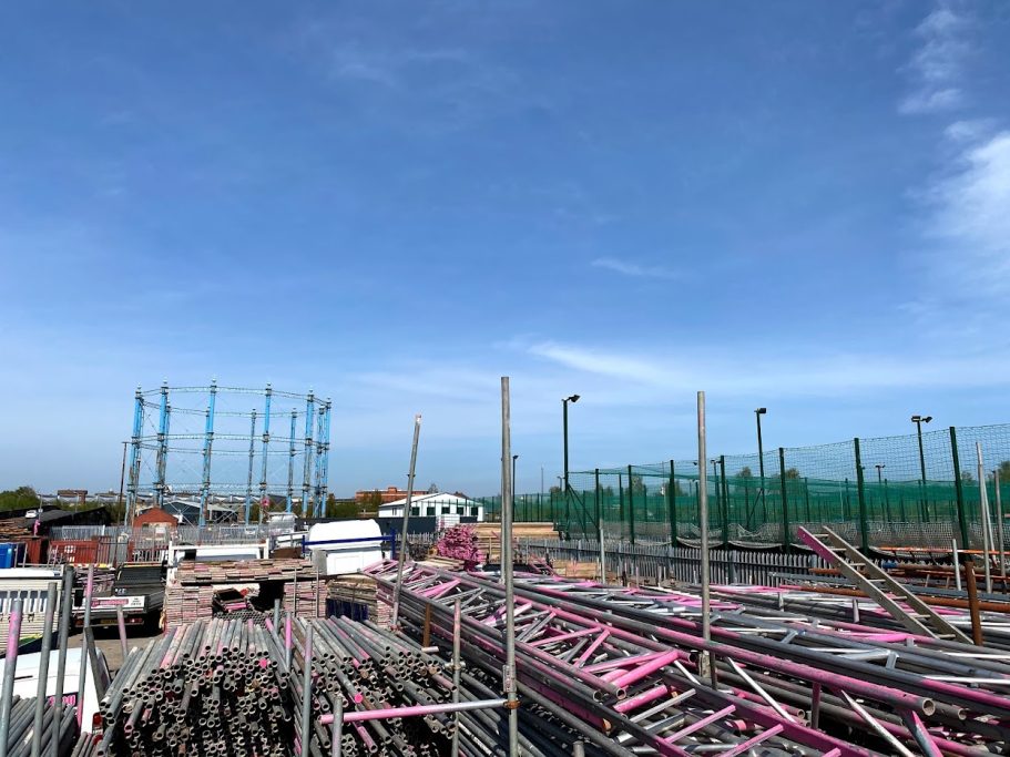Construction site with scaffolding and equipment under a clear blue sky.