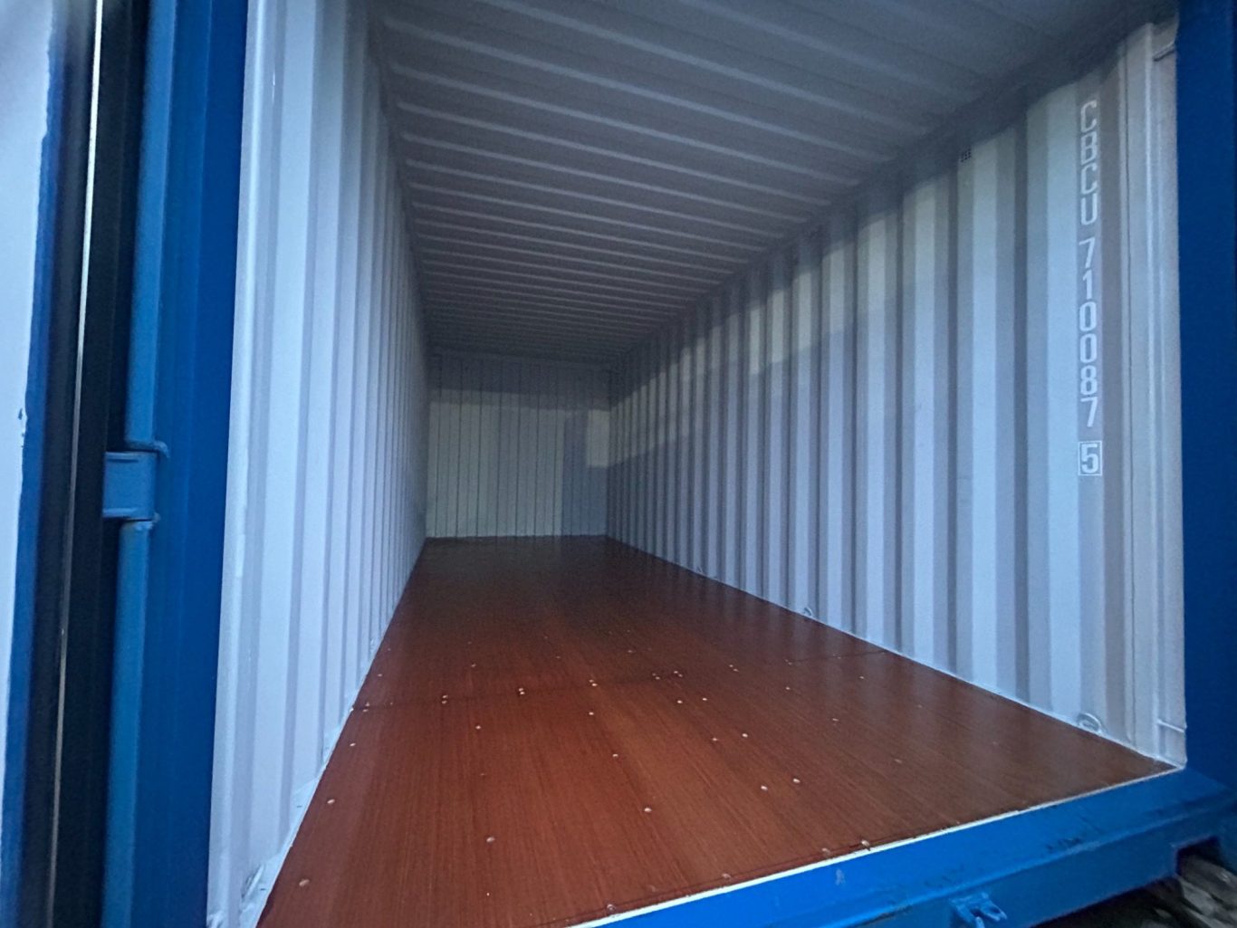 Empty shipping container showcasing a clean wooden floor and interior walls.