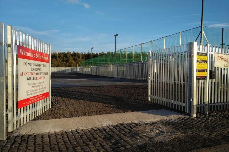Metal gates lead into a secure storage area, with signage visible nearby at Rome Street Depot in Carlisle.